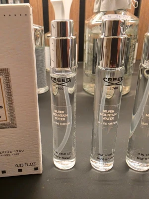  3×10mlCreed Silver Mountain Water parfym - Creed Silver Mountain Water Eau de Parfum i smidig 10 ml sprayflaska. Flaskan är genomskinlig med silverfärgad spraykork och tydlig logga. En exklusiv och fräsch doft med modern design, perfekt att ha med sig i väskan.