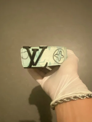 Lager 157 - Ett fint ljusblått bälte med ”bubbliga” detaljer. Kontakta vid minsta lilla!! Storlek 125
