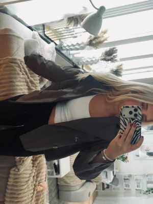 Mörkbrun oversized trenchcoat  - Snygg mörkgrön oversized kavaj med klassisk krage och två knappar framtill. Rak passform och långa ärmar, perfekt att styla till både jeans och kjol. . Enkel och trendig design.