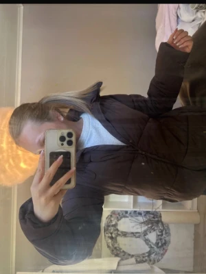 Brun pufferjacka med dragkedja - Mörkbrun pufferjacka med hög krage och dragkedja framtill. Jackan har en oversized passform. Är välanvänd med ett par trasiga delar och fläckar, fluffet på ryggen är lite utspritt efter en tvätt💘