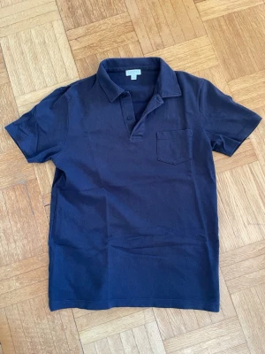 Sunspel Riviera Polo Navy - Mörkblå pikétröja i klassiska modellen Riviera från Sunspel i storlek S. Använd två gånger men tyvärr för liten. Är i mycket fint skick. Nypris 1799 kr.