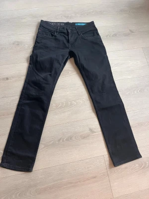 Svarta slim jeans Hilfiger Denim - Snygga svarta slim fit jeans från Hilfiger Denim. Modellen heter Scanton Slim och har klassisk femficksdesign, normalhög midja och raka ben. Perfekta för en clean och stilren look. Materialet är mjukt och stretchigt för extra komfort.