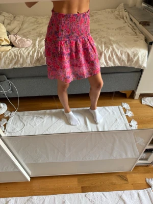 Rosa blommig kortkjol med volang - Superfin kjol från Bikbok i nyskick, aldrig använd!