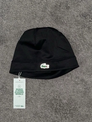 Lacoste sport mössa - Lacoste sport mössa. Helt ny 10/10. Reflective logga. Svart
