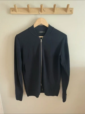 Zip cardigan J.lindeberg - Säljer min half zip tröja från J.lindeberg, då den inte längre kommer till någon användning för mig. Färgen är mörkblå. Skönt material. Storleken är true to size.   Kontakta gärna för frågor.