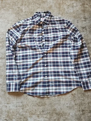Rutig skjorta från Levi's i blått och vitt - Säljer en avslappnad rutig skjorta från Levi's i blått, vitt och röda detaljer. Skjortan har klassisk krage, långa ärmar och knäppning framtill. Perfekt för en chill och stilren look.