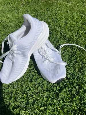 Vita mesh sneakers med snörning - Snygga helvita sneakers med ovandel i ventilerande mesh och klassisk snörning. Sulan är vit med svarta detaljer undertill för extra grepp. Perfekta för dig som gillar en clean och sportig look.Har använts som innegympaskor ett läsår. Finns på fler sidor och kommer från ett rökfritt hem, djur finns. 