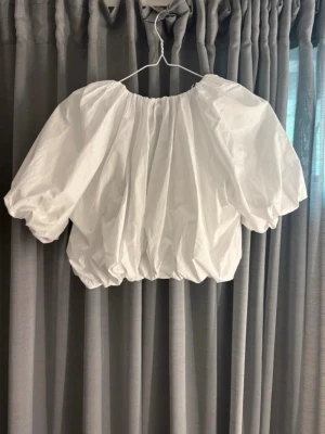 Vit croppad blus med puffärm från Zara - Superfin vit blus från Zara, jag köpte den för ett tag sedan men den är aldrig använd. Den är ny med prislapp på. Den är för liten på mig. Säljer för nypris