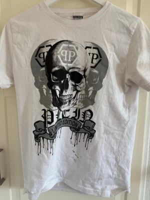 Philipp plein T-shirt  - Säljer en vit Philipp plein T-shirt med stort döskalletryck och texten 'Limited Edition' på framsidan. T-shirten har rund hals och korta ärmar. Materialet känns som bomull och trycket är i svart och grått för en edgy look.