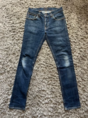 Nudie jeans - Sjukt snygga jeans från Nudie! | Byxorna är i rådenim vilket gör att de har unika samt riktigt feta slitningar och fades  | Modell: Grim Tim | Skick: 9/10 | Storlek: 32/34 | Hör gärna av dig vid frågor!!
