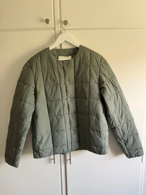 Grön jacka Arket- Helt ny! - Snygg grön jacka från Arket i storlek M. Prislappen är kvar och den är aldrig använd. Nypris 1290kr