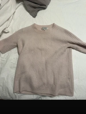 Ljusrosa Softgoat tröja  - Säljer en ljusrosa ribbstickad tröja med rund hals och halvlånga ärmar. Tröjan har en enkel och stilren design, perfekt för lager på lager och passar till många olika outfits. Materialet ser mjukt och bekvämt ut.