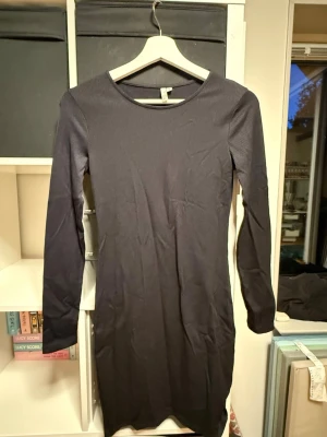 Svart ribbad långärmad klänning - En svart, ribbad klänning från Nelly i storlek S. Klänningen har lång ärm, rund halsringning och är figurnära i modellen. 