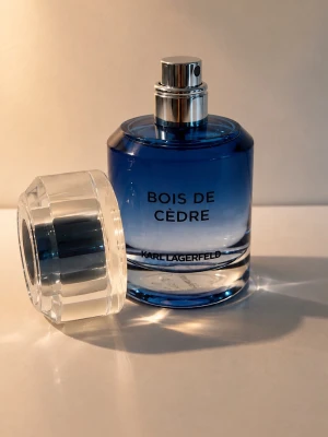 Bois de Cèdre parfym Karl Lagerfeld - Bois de Cèdre från Karl Lagerfeld är en Eau de Toilette i en snygg blå glasflaska med transparent lock. Doften är träig och fräsch, perfekt för dig som gillar eleganta och moderna parfymer. Flaskan har en stilren design och känns lyxig i handen.