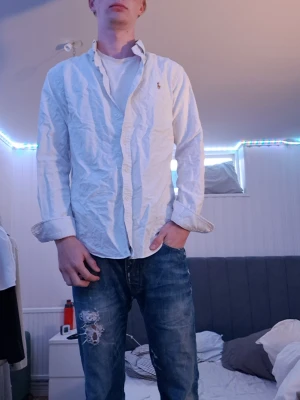 Vit skjorta från Polo Ralph Lauren M - Klassisk vit skjorta från Polo Ralph Lauren i slim fit-modell. Skjortan har långa ärmar, knappar framtill och den ikoniska lilla broderade loggan på bröstet.