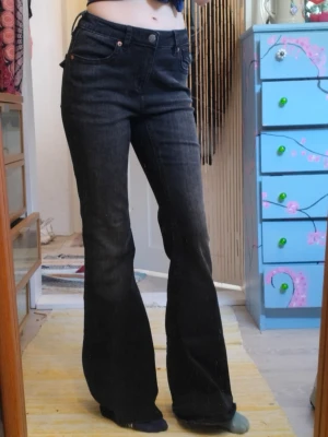 Stradivarius Svarta bootcut jeans  - Säljer ett par svarta bootcut jeans med hög midja och klassiska fem fickor. Jeansen har utsvängda ben och stängs med knapp och dragkedja. Snygga till crop tops eller hoodies och perfekta för dig som gillar retrovibbar. Från stradivarius 