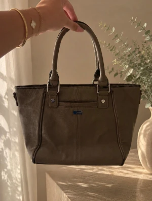  handväska med ormmönster - Snygg och rymlig grå väska med reptilmönstrat parti. Använd och har tecken på användning, se bilder för skick. 👜 