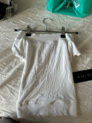 Vit offshoulder topp från Amisu - Säljer en vit offshoulder topp från Amisu. Toppen är ribbad i kanterna och har en croppad passform med korta ärmar. Perfekt till sommaren och enkel att matcha med olika stilar.