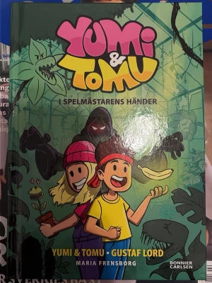 Yumi & Tomu: I Spelmästarens händer SIGNERAD - Färgstark och spännande bok med Yumi & Tomu, där de hamnar i ett äventyr fyllt av köttätande blommor och radioaktiva bananer. SIGNERAD!!!💕