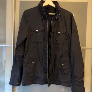 J.Lindeberg field jacket Xs - Säljer min J.Lindeberg jacka i färgen mörkblå. Jackan är i storlek XS. Jackan är i fint skick och endast använd ett fåtal gånger. Denna version är slutsåld därav priset. Jackan passar perfekt till våren och hösten. Nypris 2799 kr.
