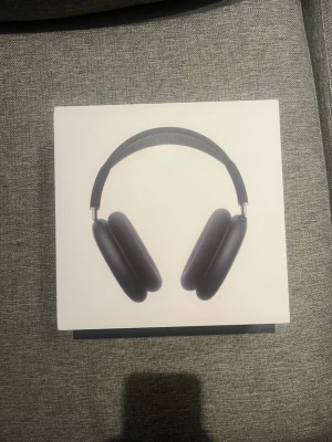 AirPods Max hörlurar - Snygga svarta AirPods Max hörlurar med stilren design och mjuka öronkuddar. Bågen är vadderad och har metallinslag för extra hållbarhet. Perfekta för musik, gaming eller film och ger grymt ljud och komfort.