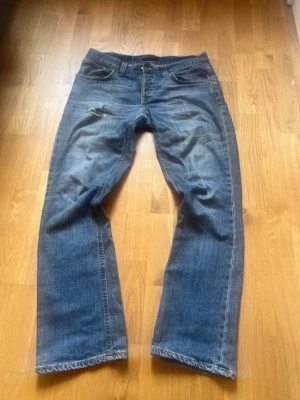 Nudie Jeans Regular Ralf  - Säljer dessa nudie Regular Ralf till ett bra pris! Storlek 32/32! Midja 43 och längd 102! OBS lagning i skrevet men syns ej så mycket vid användning! Pris går att diskutera vid snabb affär! Hör av dig vid minsta fundering! 