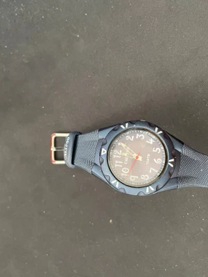 Blå sportig klocka från CAMYCO - Snygg blå klocka från CAMYCO med rund urtavla och tydliga siffror. Klockan har ett sportigt utseende med ett robust armband i syntetmaterial och detaljer i silver. Perfekt för dig som gillar en enkel men cool accessoar.
