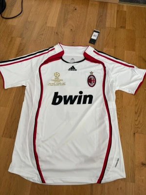 AC Milan bortatröja Maldini #3 - Säljer en vit AC Milan bortatröja från Adidas med Maldini nummer 3 på ryggen. Champions League-finaltryck, perfekt för fotboll eller samling.