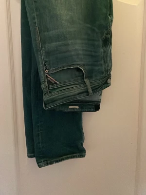 Replay Rocco 34/34 - Säljer ett par blå jeans från Replay med snygga slitningar på bensluttning och fickor och tvättade detaljer. Klassisk femficksmodell med raka ben och normal midja.