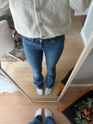 Blå bootcut jeans med midwaist - Snygga blå jeans med bootcut passform och midwaist. Jeansen har klassisk femficksdesign och stängs med knapp och dragkedja. (Jag är 176 cm)