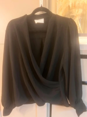 Svart omlottblus med långa ärmar - Säljer min svarta blus från neo nior , super fint skick 