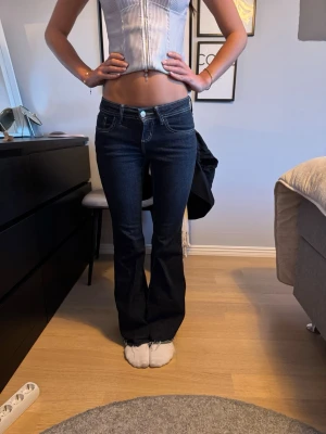 Mörkblå lowaist bootcut jeans  - Säljer ett par mörkblå bootcut jeans från Nelly som tyvärr är för små för mig. (Har klippt nertill på dem) Är 165cm som referens💕Kan gå ner i pris vid snabb affär!