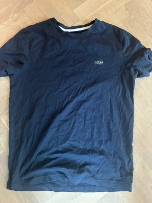 Marinblå t-shirt från BOSS - Blå T-shirt från BOSS i bra skick. Skön och ganska åtsittande. Storlek M
