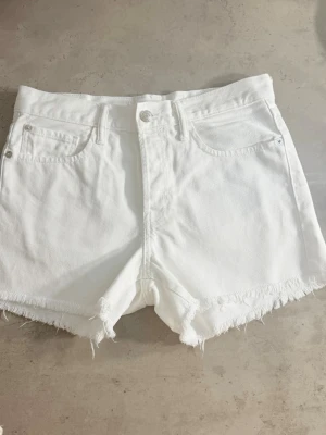 Vita jeansshorts med fransig kant Mango - 🎀 Elegant svart minikjol med en stor dekorativ rosett framtill ✨ Glansigt, festligt tyg 🖤 Figurnära modell med dold dragkedja baktill 🥂 Perfekt för fest, middag, nyår eller andra speciella tillfällen 📏 Storlek 38/M. Mått finns på bilderna.  Jag erbjuder mängdrabatt vid köp av flera varor. Se gärna mina andra annonser.