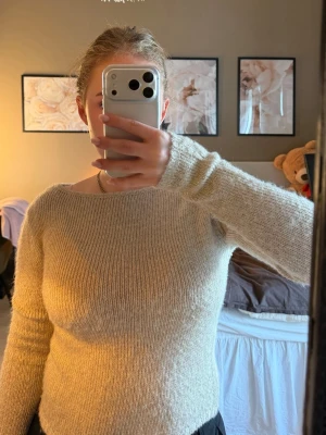 Beige glittrig stickad tröja  - Mysig beige stickad tröja med rund halsringning och långa ärmar. Tröjan har en enkel, rak passform och är tillverkad i ett mjukt, lätt material som passar perfekt till vardags. Stilren och enkel att matcha med olika outfits.