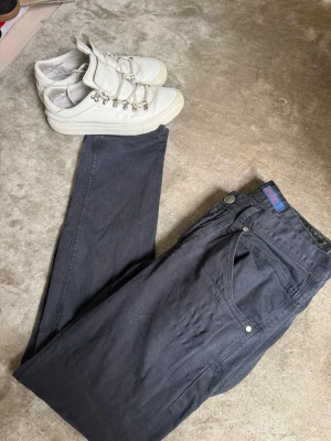 Gabba jeans - Säljer ett par mörkblå jeans med rak passform och klassisk femficksdesign. Jeansen har silverfärgade nitar och knapp, samt en diskret etikett i midjan. Perfekta till vardagslooken och passar till det mesta.