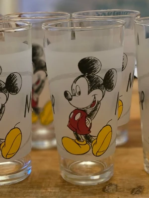 Disney Musse Pigg glas med tryck - Sex stycken genomskinliga glas med tryck av Musse Pigg i rött, gult och svart. Glasen har en klassisk rak form och motivet visar Musse Pigg i sina ikoniska röda byxor och gula skor. Perfekta för dryck eller som dekoration. Mått höjd 14 cm, Diam  7 cm