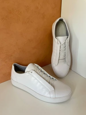 Vita loafers i skinn från Vagabond, stl 42, nya oanvända  - Säljer ett par stilrena vita loafers från Vagabond i mjukt skinn. Skorna har en minimalistisk design med elastiska band istället för klassiska snören och en låg sula. Perfekta för dig som gillar en clean och modern look. Stl 42 nya oanvända, äkta skinn 