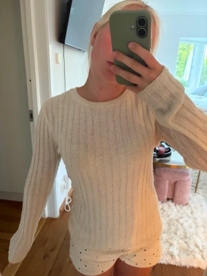 Krämvit finstickad topp -  Krämvit ribbad stickad tröja från Bikbok. Har inte använt den så mycket så den är i bra skick, det finns ett litet hål vid halsen där bak som man inte märker.