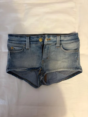 Weekday shorts - Säljer ett par ljusblå denimshorts med klassisk femficksdesign och bälteshällor. Shortsen har knapp och dragkedja framtill och är perfekta för varma dagar. Snygg, enkel stil som passar till det mesta. 
