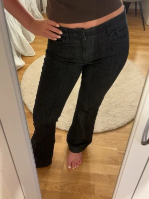 Svarta raka jeans med hög midja - Säljer ett par svarta jeans med rak passform och medel midja. Jeansen har klassiska fem fickor och stängs med dragkedja och knapp. Materialet är denim med en lätt stretch för extra komfort. Perfekta till en avslappnad och trendig look.