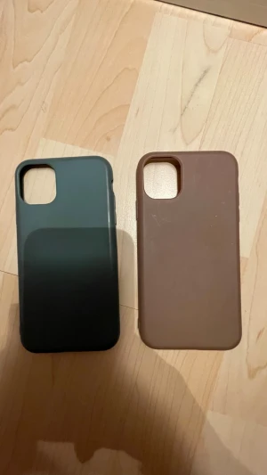 Två stilrena mobilskal i silikon - Säljer två mobilskal i silikon, ett i mörkgrönt och ett i brunt. Båda har en matt finish och är designade för att skydda din mobil med snygg och enkel look. Passar perfekt för dig som vill ha ett minimalistiskt och modernt skal. Passar både tlll en IPhone XR och 11. 