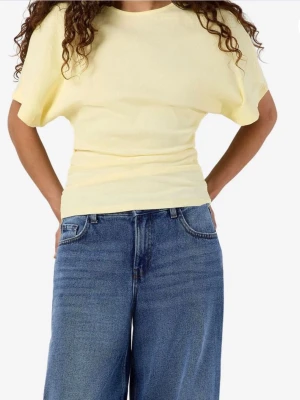 Ljusgul ribbad topp med kort ärm - Snygg ljusgul topp med ribbad struktur och korta ärmar. Modellen har en kroppsnära passform i midjan och en lösare överdel. Perfekt att styla med jeans eller kjol för en fräsch look.