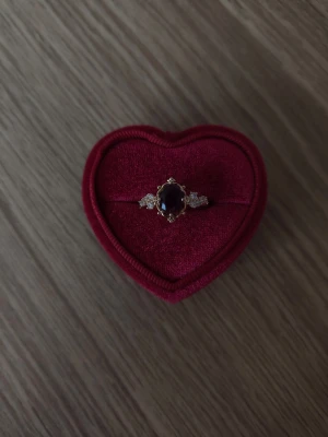 Guldring med mörklila sten och kristaller - Mörklila kristall ring i storlek 18,1mm, guldfärgad.