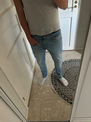Ljusblå slim fit jeans - Säljer ett par ljusblå slim fit jeans med klassisk femficksdesign och normal midja. Jeansen har en snygg tvätt och raka ben som smalnar av nedtill. Passar perfekt till en avslappnad och trendig stil.