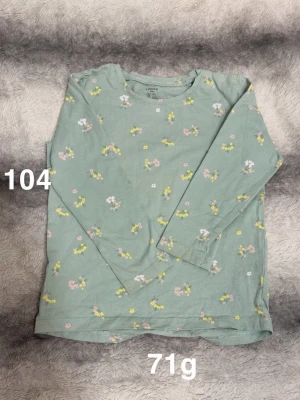 Grön blommig långärmad topp - Söt grön långärmad topp med små blommor i vitt, rosa och gult. Perfekt för dig som gillar mjuka färger och blommigt mönster. 🌸 Fint använt skick. Storlek 104