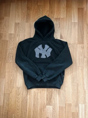 Skogsgrön hand-made hoodie NY logga - Tjena, jag säljer denna riktigt feta hoodien jag gjort själv. Det är en skogsgrön hoodie med grått jeanstyg i form av New York yankees loggan.  XS   100% bomull  Skogsgrön  55cm lång 47cm axelbredd Alltså en lite mer ”Boxy” passform   Originalhoodien är från Vailent/Carlings  Hör av dig om du undrar något, priset är inte fast!