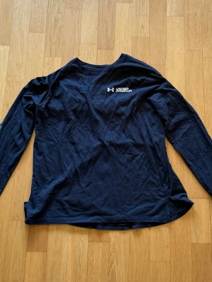 Långärmad tröja Under Armour - Långärmad tröja från Under Armour med tryckt logga på bröstet.