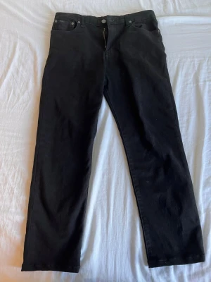 Svarta raka jeans - Säljer ett par svarta jeans med rak passform och klassisk femficksdesign. Jeansen har bälteshällor och knappgylf. Materialet är bomullsdenim. Perfekta till en grish look. Pris går att diskutera