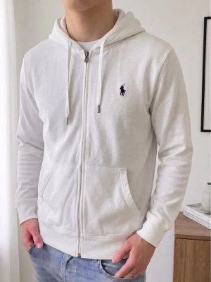 Vit Ralph Lauren zip hoodie - Säljer en sjukt fet zip hoodie från Ralph Lauren. Hoodien är i bra skick utan nåra defekter och är färgen vit. Den är i strl M och sitter även som en M! Hör gärna av er vid frågor elr funderingar!! 